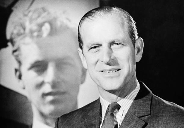 Prince Philip, Duke of Edinburgh, with a photograph of his younger self, circa 1975.