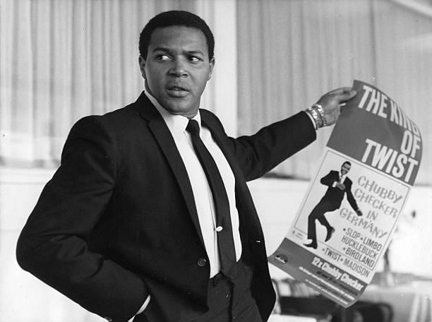 Portrait of Chubby Checker holding up his tour poster in 1964 in Hamburg, Germany.