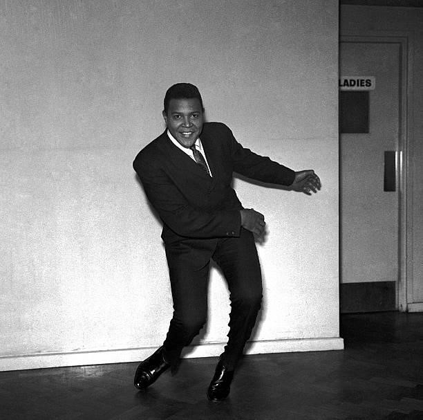 Chubby Checker, posed, in corridor, doing the twist, 1961.