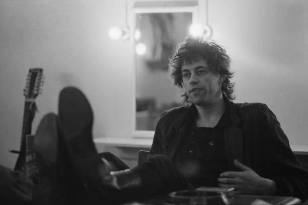 Irish singer-songwriter Bob Geldof in discussion, with his feet up on the table in front of him, 11th March 1985.