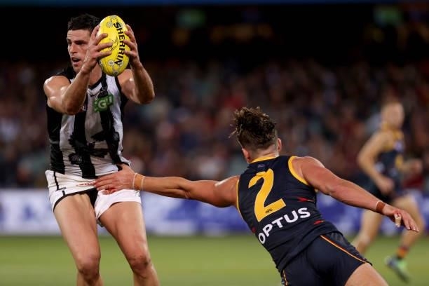 Scott Pendlebury of the Magpies is tackled by Ben Keays of the Crows during the 2021 AFL Round 12 match between the Adelaide Crows and the...