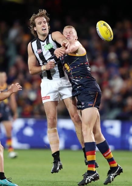 Max Lynch of the Magpies and Reilly O'Brien of the Crows compete for the ball during the 2021 AFL Round 12 match between the Adelaide Crows and the...