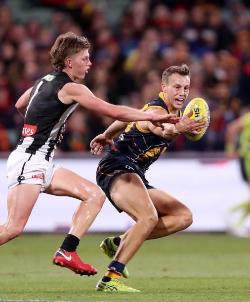 Tom Doedee of the Crows runs the ball against Jay Rantall of the Magpies during the 2021 AFL Round 12 match between the Adelaide Crows and the...