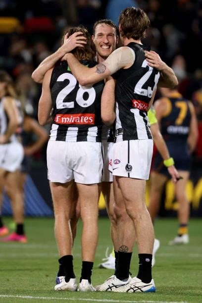 Nathan Murphy, Jack Madgen and Jordan Roughead of the Magpies celebrate their win during the 2021 AFL Round 12 match between the Adelaide Crows and...