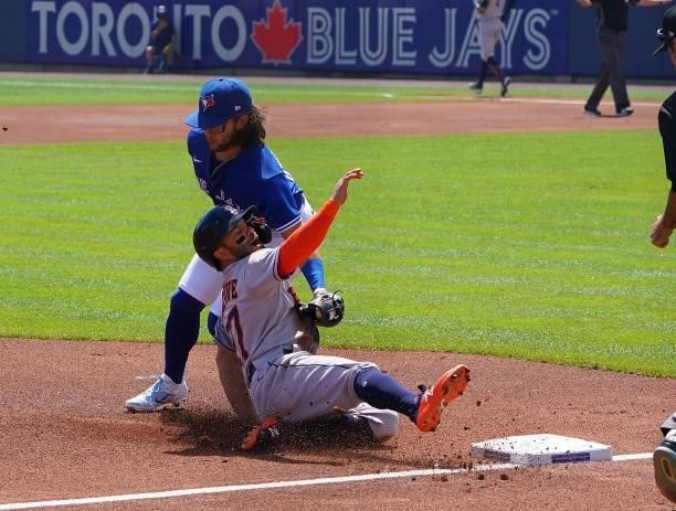 Bo Bichette of the Toronto Blue Jays tags out Jose Altuve of the Houston Astros at third base during the first inning at Sahlen Field on June 5, 2021...