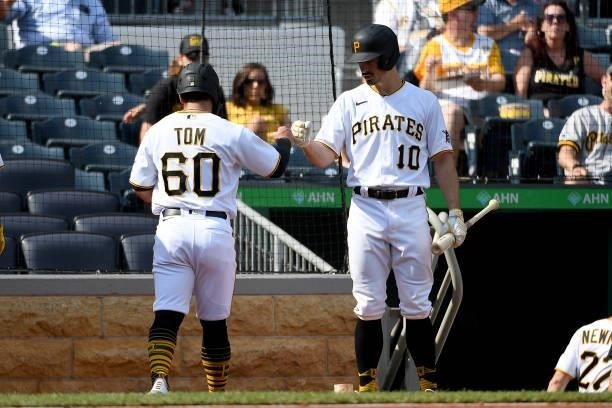 Ka'ai Tom of the Pittsburgh Pirates celebrates with Bryan Reynolds after coming around to score on a two-run RBI single by Adam Frazier in the second...