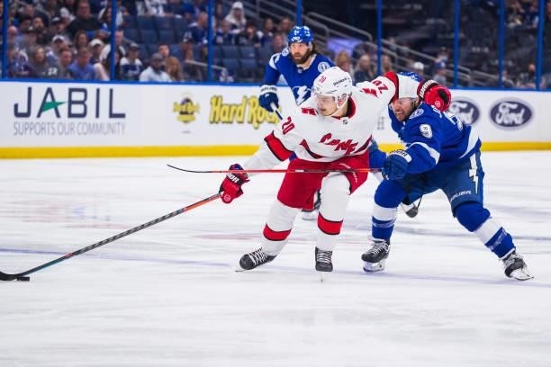 Sebastian Aho of the Carolina Hurricanes races against Tyler Johnson of the Tampa Bay Lightning during the second period in Game Four of the Second...