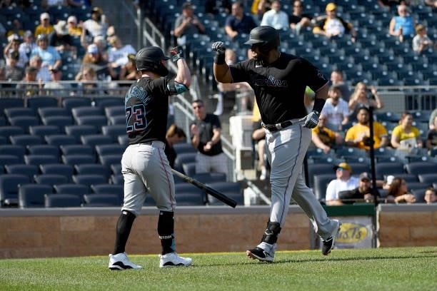 Jesus Aguilar of the Miami Marlins high fives with Corey Dickerson after hitting a solo home run in the fourth inning during the game against the...