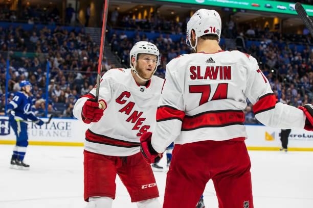 Steven Lorentz and Jaccob Slavin of the Carolina Hurricanes celebrate a goal against the Tampa Bay Lightning during the second period in Game Four of...