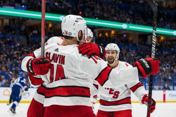 Steven Lorentz, Jaccob Slavin, and Cedric Paquette of the Carolina Hurricanes celebrate a goal against the Tampa Bay Lightning during the second...