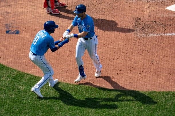 Andrew Benintendi of the Kansas City Royals celebrates with Nicky Lopez after hitting a home run against the Minnesota Twins in the fifth inning at...