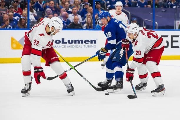 Ondrej Palat of the Tampa Bay Lightning skates against Brett Pesce and Sebastian Aho of the Carolina Hurricanes during the third period in Game Four...