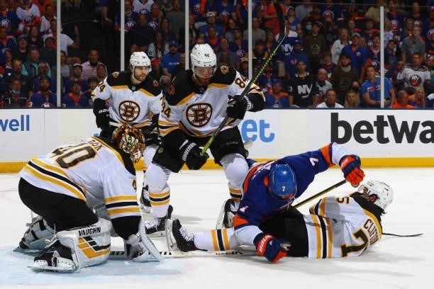 Jordan Eberle of the New York Islanders falls on top of Connor Clifton of the Boston Bruins as they compete for the puck during the first period in...