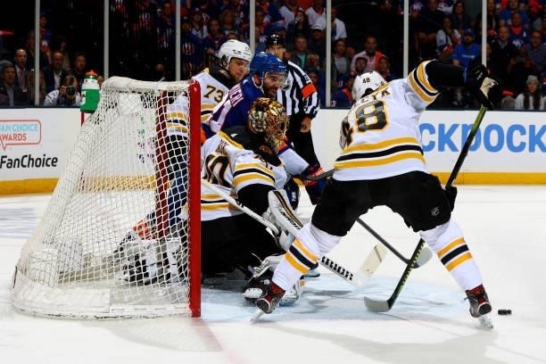 Matt Grzelcyk and Tuukka Rask of the Boston Bruins save a shot on goal by the New York Islanders during the first period in Game Four of the Second...