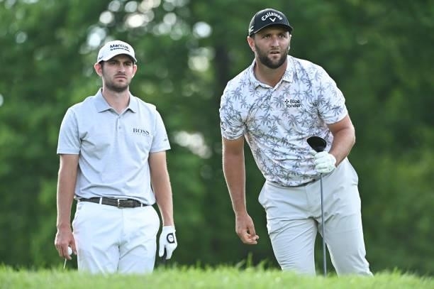 Jon Rahm of Spain watches his drive on the 18th tee box as Patrick Cantlay watches during the third round of the Memorial Tournament presented by...