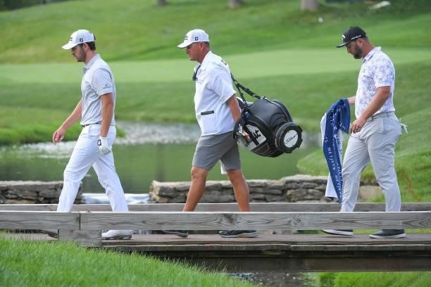 Patrick Cantlay and Jon Rahm of Spain walk across a bridge on the 15th hole during the third round of the Memorial Tournament presented by Nationwide...