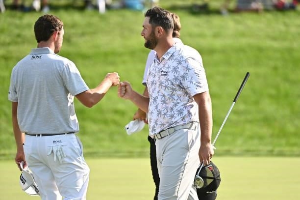 Patrick Cantlay and Jon Rahm of Spain fist bump on the 18th green during the third round of the Memorial Tournament presented by Nationwide at...