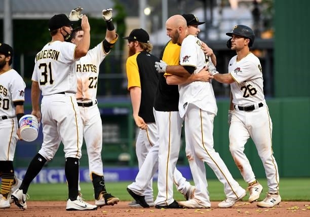 Jacob Stallings of the Pittsburgh Pirates celebrates with teammates after hitting a walk off single in the thirteenth inning to give the Pirates a...
