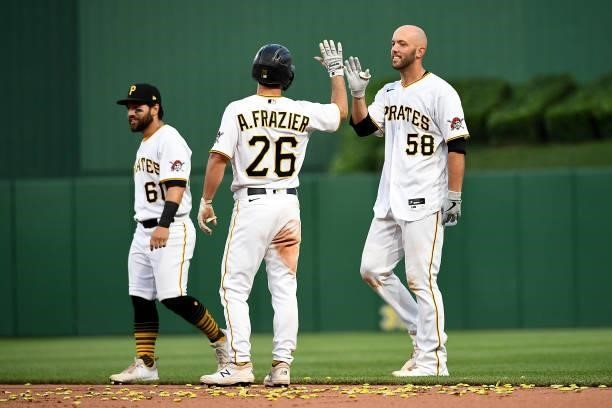Jacob Stallings of the Pittsburgh Pirates high fives with Adam Frazier after hitting a walk off single in the thirteenth inning to give the Pirates a...