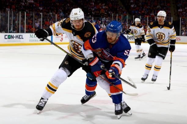 Casey Cizikas of the New York Islanders and Jeremy Lauzon of the Boston Bruins race for the puck during the first period in Game Four of the Second...