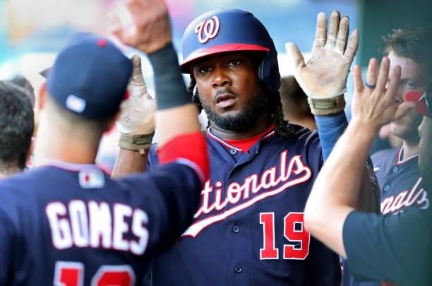 Josh Bell of the Washington Nationals high-fives teammates in the dugout after hitting a solo home run in the eighth inning during a game against the...