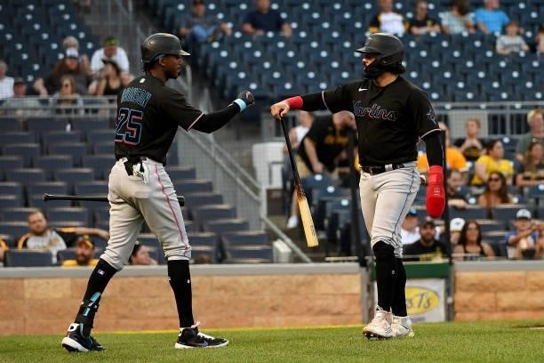 Jorge Alfaro of the Miami Marlins celebrates with Lewis Brinson after coming around to score on a sacrifice fly ball by Isan Diaz in the tenth inning...