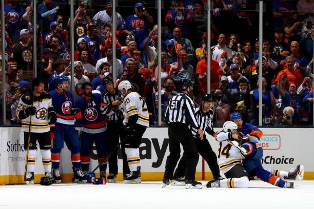 Fans watch as Jarred Tinordi of the Boston Bruins and Matt Martin of the New York Islanders fight during the first period in Game Four of the Second...