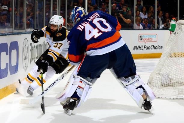 Patrice Bergeron of the Boston Bruins reaches for the puck against Semyon Varlamov of the New York Islanders during the second period in Game Four of...