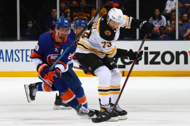 Charlie McAvoy of the Boston Bruins handles the puck against Brock Nelson of the New York Islanders during the second period in Game Four of the...