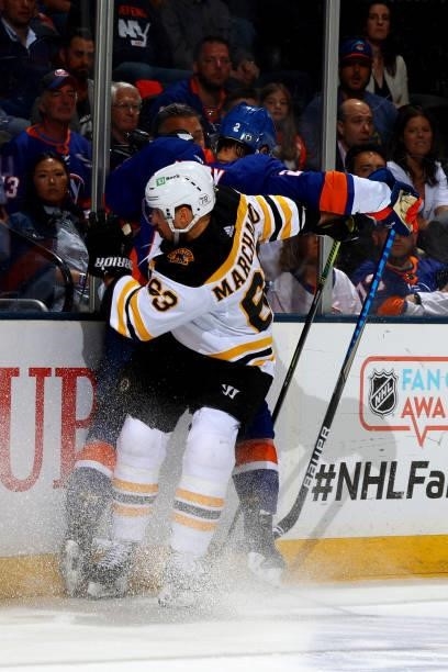 Brad Marchand of the Boston Bruins checks Nick Leddy of the New York Islanders into the boards during the second period in Game Four of the Second...