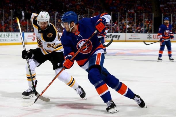 Noah Dobson of the New York Islanders and Sean Kuraly of the Boston Bruins race for the puck during the second period in Game Four of the Second...