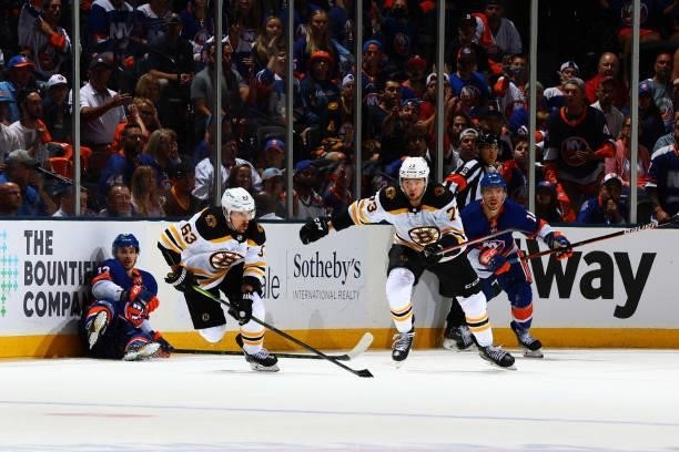 Brad Marchand and Charlie McAvoy of the Boston Bruins chase the puck against Mathew Barzal and Anthony Beauvillier of the New York Islanders during...