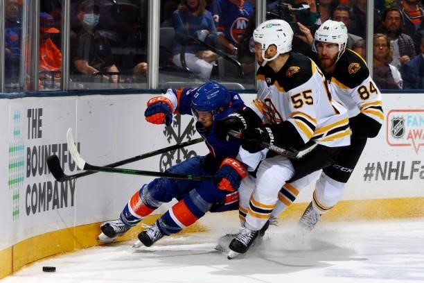 Mathew Barzal of the New York Islanders competes for the puck against Jeremy Lauzon and Jarred Tinordi of the Boston Bruins during the third period...