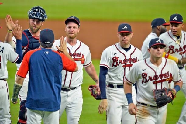 Kevan Smith, Will Smith, Freddie Freeman and Austin Riley of the Atlanta Braves walk off the field after beating the Los Angeles Dodgers 6-4 at...
