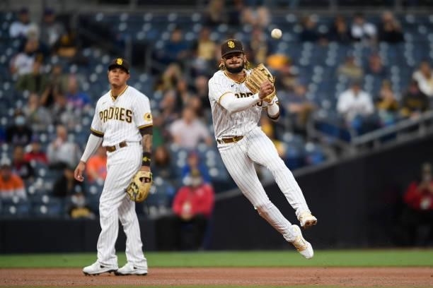 Fernando Tatis Jr. #23 of the San Diego Padres throws out Kevin Pillar of the New York Mets as Manny Machado looks on during the first inning of a...