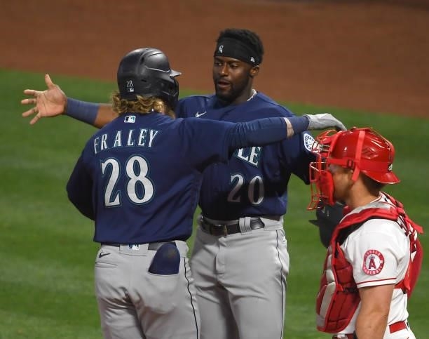 Jake Fraley of the Seattle Mariners is congratulated by Taylor Trammell after hitting a grand slam home run in the fourth inning of the game against...