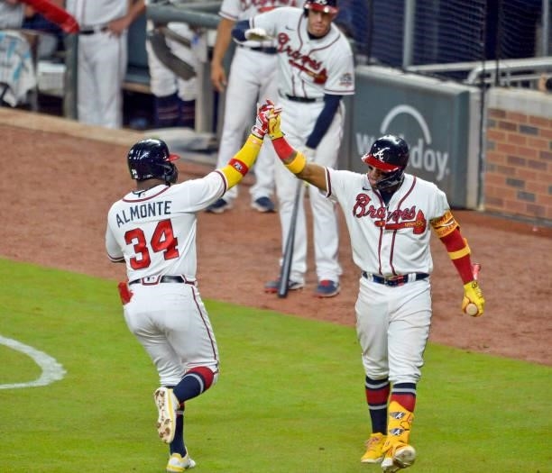 Abraham Almonte of the Atlanta Braves high fives Ronald Acuña Jr. #13 after hitting a home run in the bottom of the seventh inning against the Los...