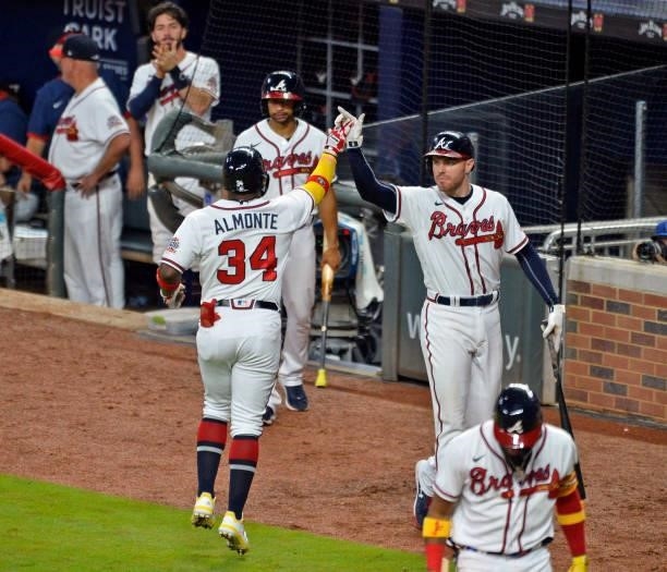 Abraham Almonte of the Atlanta Braves high fives Freddie Freeman after hitting a home run in the bottom of the seventh inning against the Los Angeles...