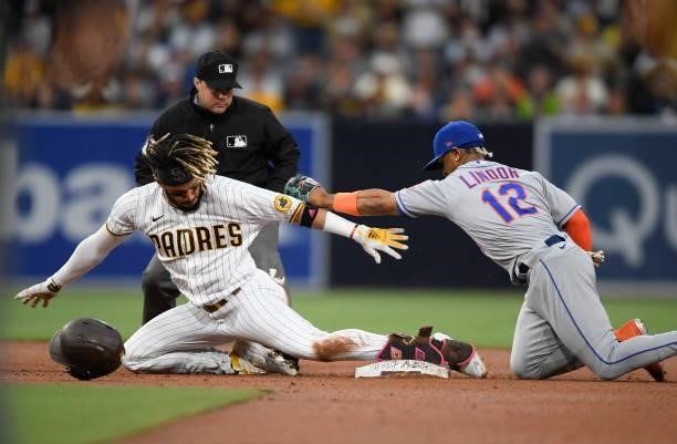 Fernando Tatis Jr. #23 of the San Diego Padres slides into second base on a double ahead of the tag by Francisco Lindor of the New York Mets during...
