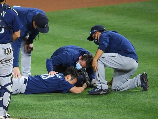 Yusei Kikuchi of the Seattle Mariners receives medical attention on the field after he was hit by a line drive by David Fletcher of the Los Angeles...