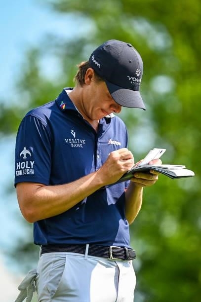 Carlos Ortiz of Mexico updates his scorecard in his yardage book on the 12th tee during the third round of the Memorial Tournament presented by...