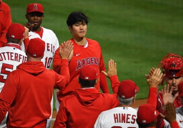 Shohei Ohtani of the Los Angeles Angels celebrates with the team after the final out of the ninth inning against the Seattle Mariners at Angel...