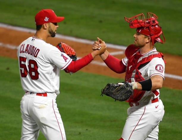 Alex Claudio of the Los Angeles Angels is congratulated by Max Stassi after pitching a scoreless ninth inning against the Seattle Mariners at Angel...