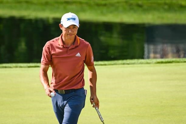 Collin Morikawa smiles and waves his ball to fans after saving par on the 16th hole green during the third round of the Memorial Tournament presented...