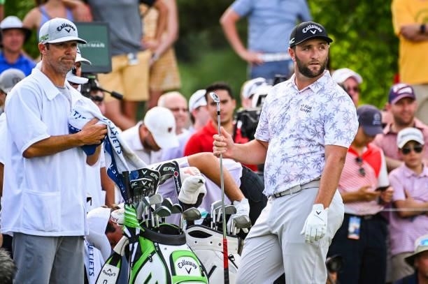 Jon Rahm of Spain hands his club to his caddie after playing his shot from the 16th tee during the third round of the Memorial Tournament presented...