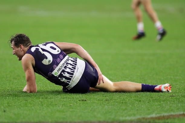 Brennan Cox of the Dockers grabs his right hamstring during the 2021 AFL Round 12 match between the Fremantle Dockers and the Western Bulldogs at...