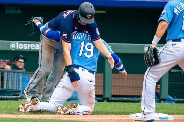 Alex Kirilloff of the Minnesota Twins attempts to maneuver around the tag from Kelvin Gutierrez of the Kansas City Royals after over running second...