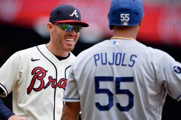 Freddie Freeman of the Atlanta Braves smiles at Albert Pujols of the Los Angeles Dodgers after a Pujols base hit in the top of the 4th inning at...