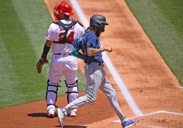 Crawford of the Seattle Mariners crosses the plate for a run in the first inning of the game against the Los Angeles Angels at Angel Stadium of...