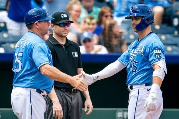 Whit Merrifield of the Kansas City Royals celebrates with third base coach Vance Wilson of the Kansas City Royals after connecting on a Minnesota...